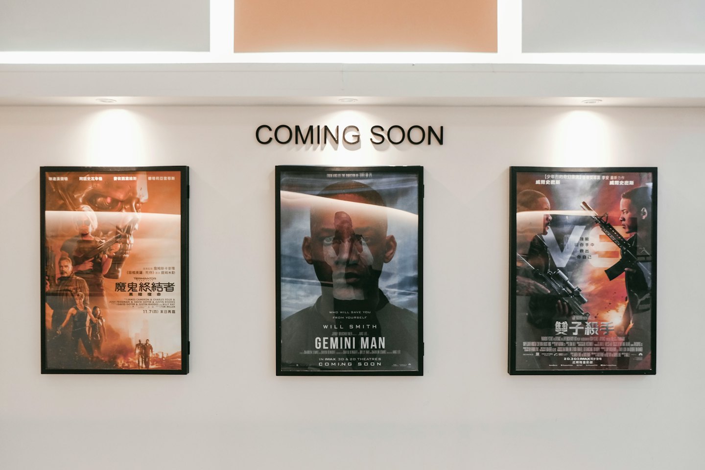 Tre poster di film incorniciati sono appesi a una parete bianca.